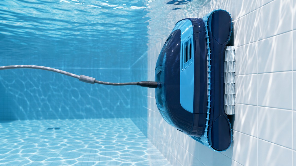 Robot pulitore elettrico Dolphin che si arrampica sulla parete interna di una piscina con liner azzurro