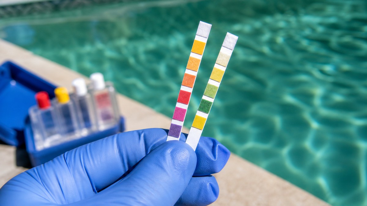 Strisce di analisi dell'acqua di piscina che mostrano pH e cloro durante un trattamento shock