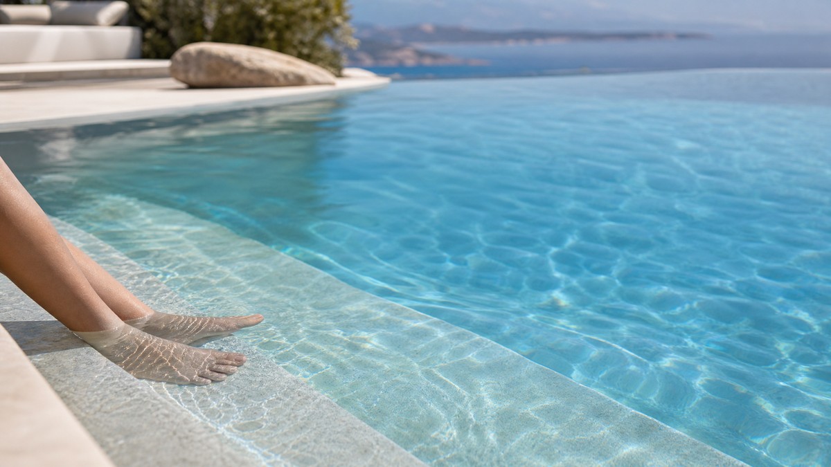 Piscina residenziale di acqua salata con bagnanti che entrano dalle scale al tramonto
