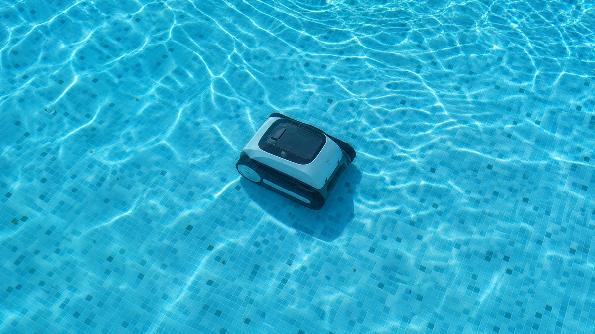 Robot pulitore senza fili che lavora a metà ciclo in una piscina residenziale cristallina